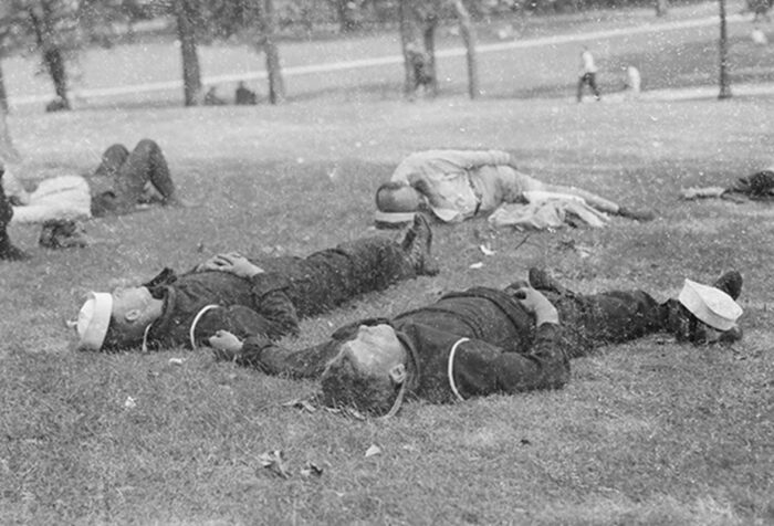black and white photo of sailors lying on Boston Common