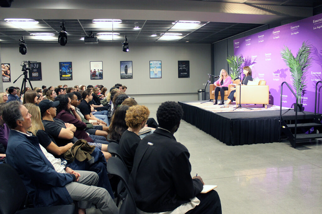 Audience watches two women on a low stage 