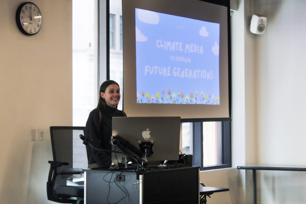 Suzie Hicks smiles in front of a classroom to talk with students
