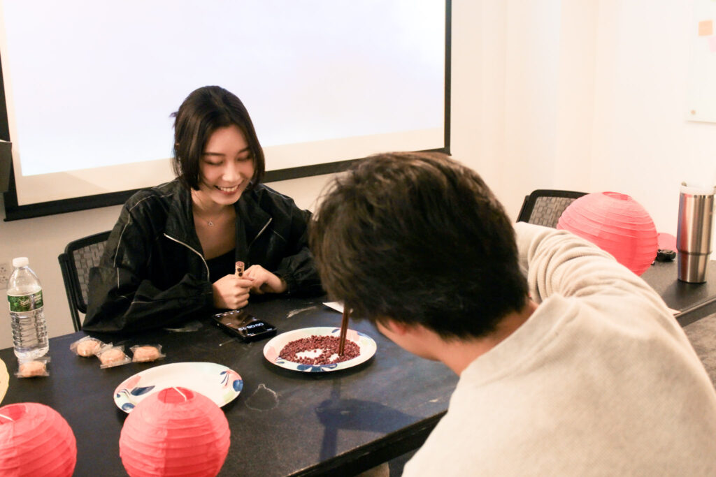 Two students compete in a chopstick challenge