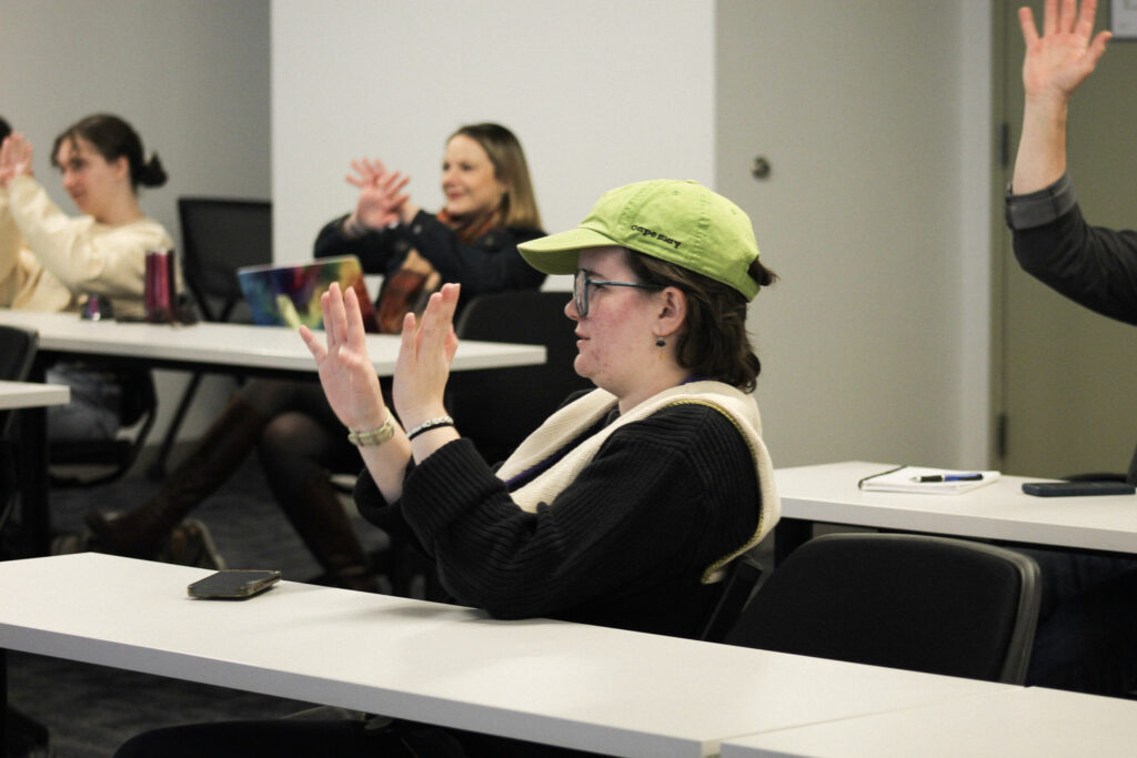 Audrey Larson has her hands up while other students do too in the background