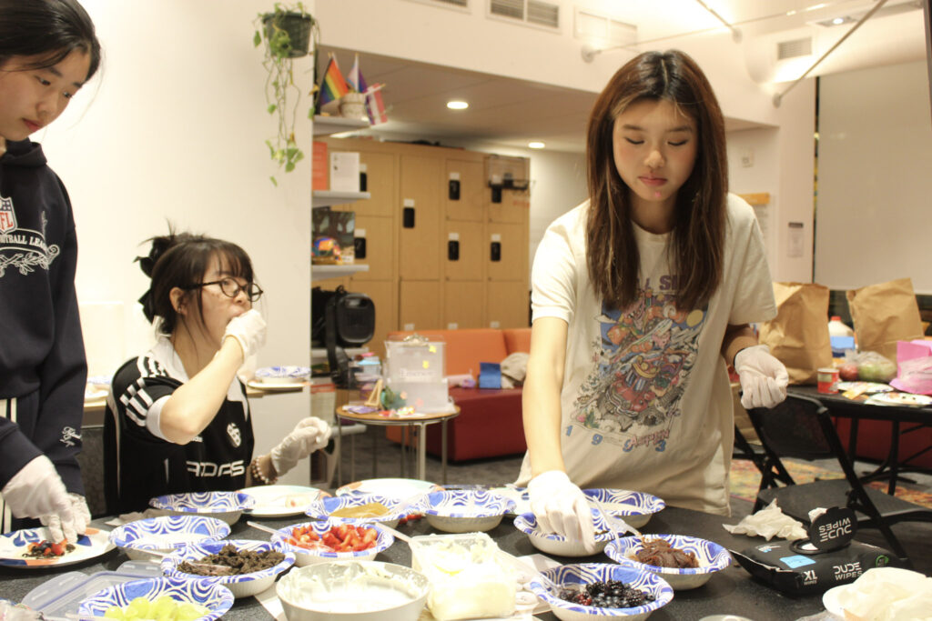 One student eats while another makes food