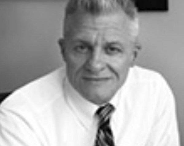 Headshot of a man wearing a white dress shirt and dark tie.