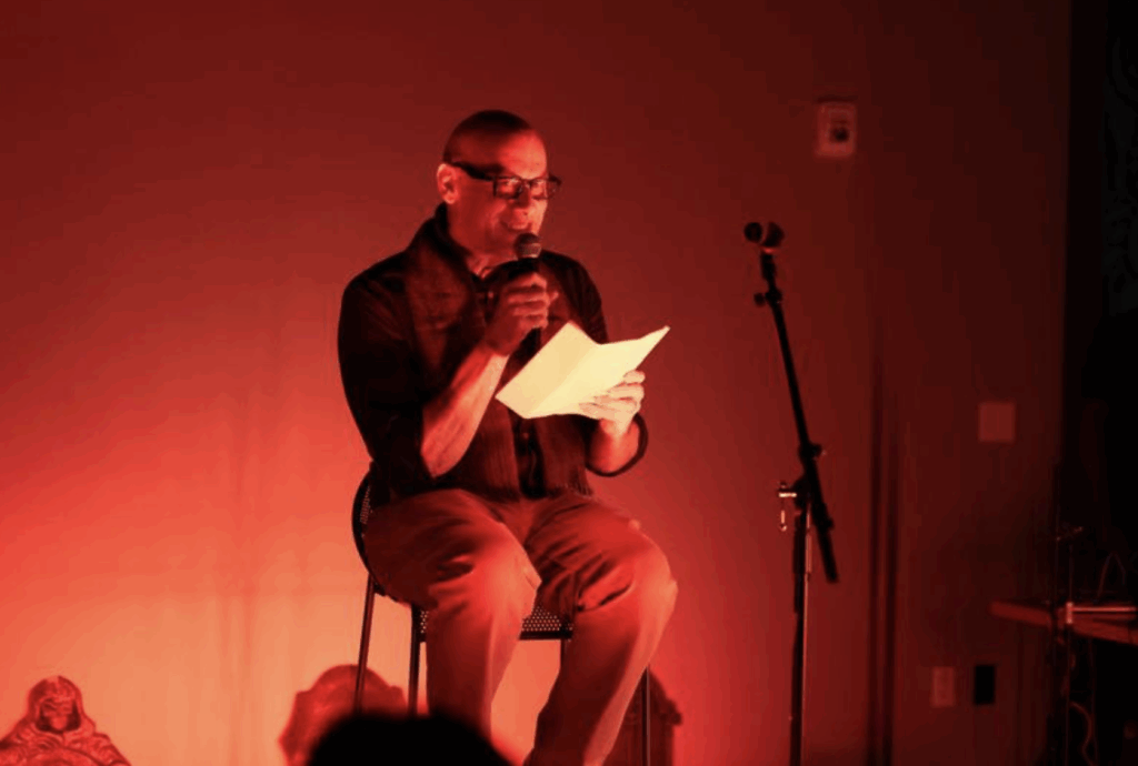 a person performs on stage while sitting and holding a piece of paper