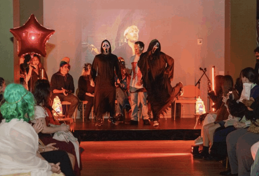 Two people dressed wearing the Scream mask are on stage