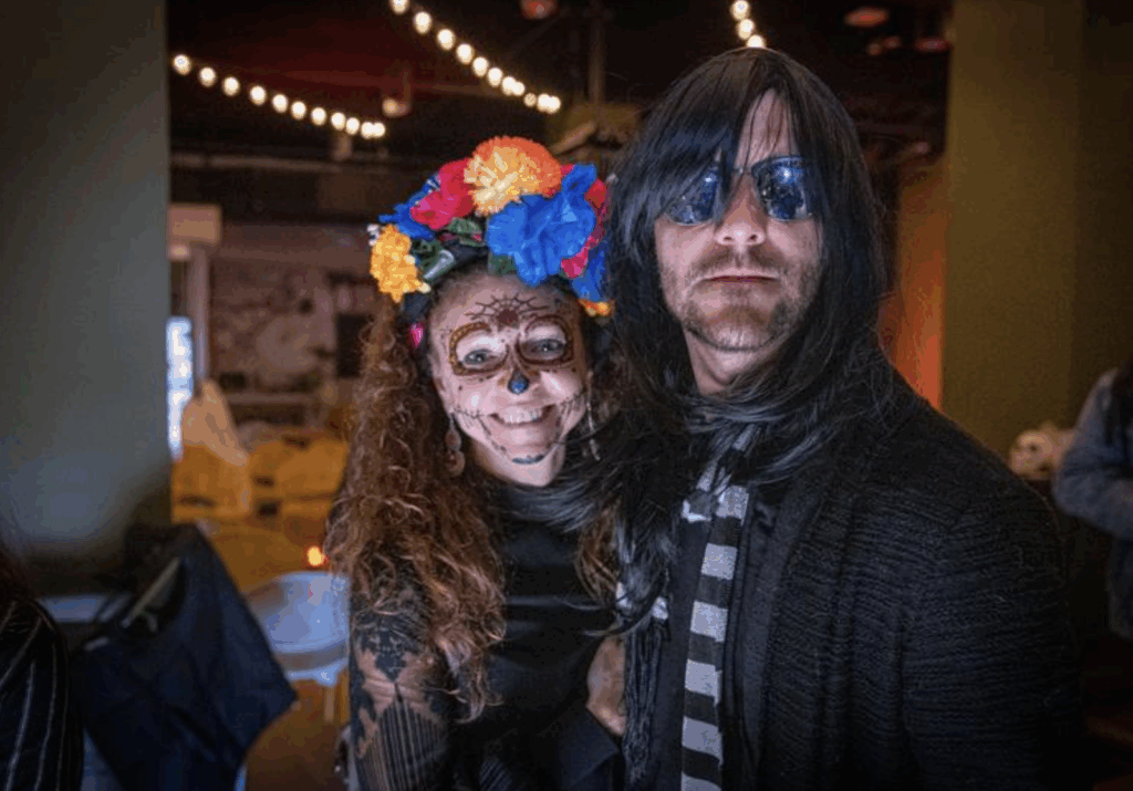 Two people pose for a photo wearing costumes