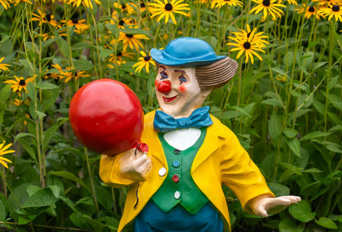 clown statue in field of flowers