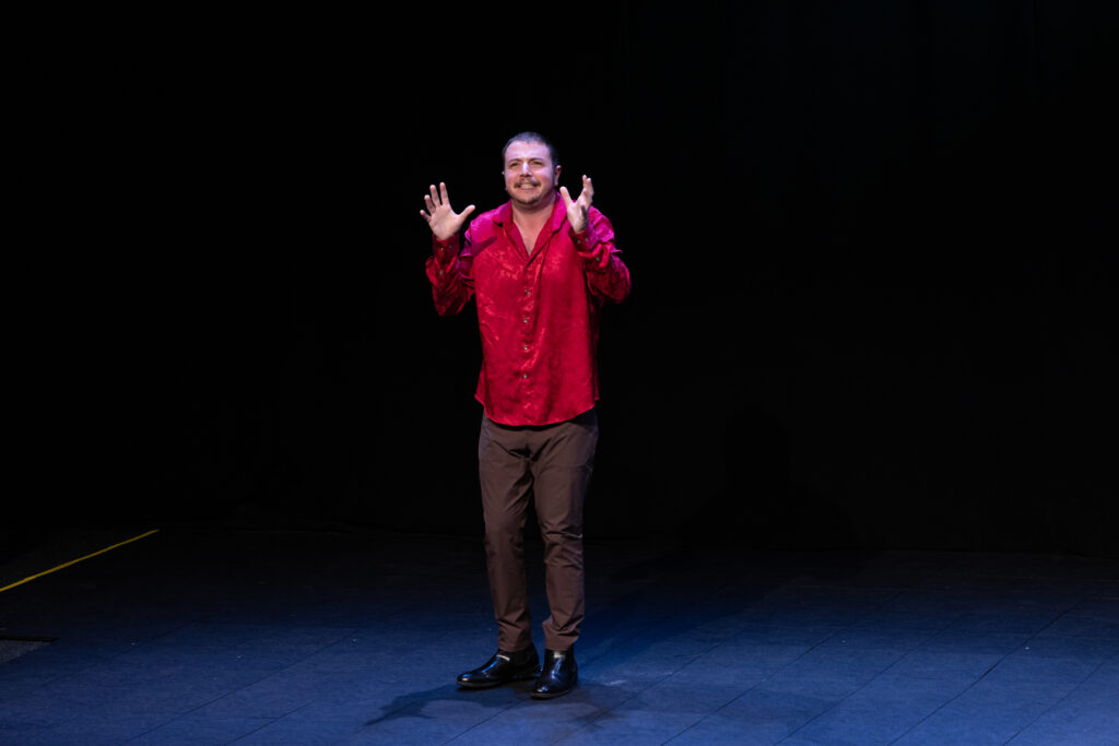 A person holds up their hands while performing on stage