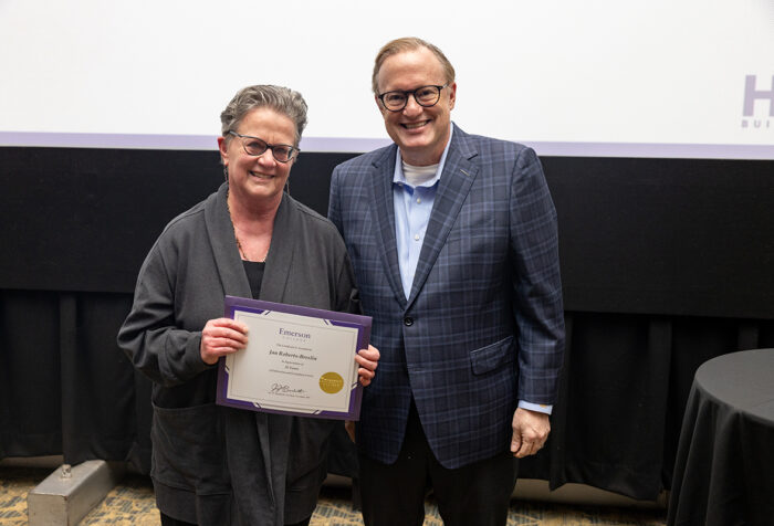 Jan Roberts-Breslin holds a certificate, stands next to Jay Bernhardt