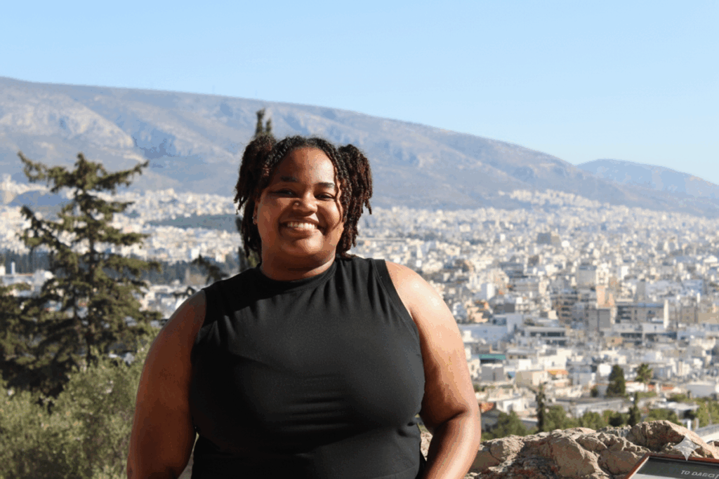 Amyah Bishop smiles with a town behind her