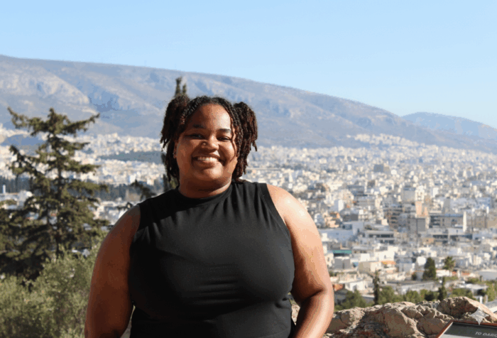 Amyah Bishop smiles with a town behind her