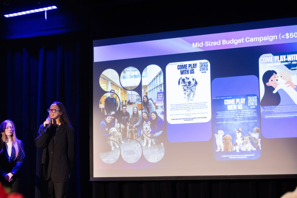 A person stands near a screen projection of the group's project