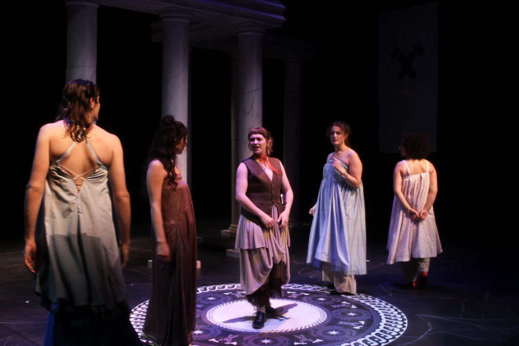 Five people in stage in toga-like garb