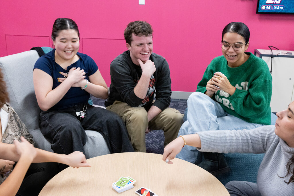Several students sit around a table while playing Uni