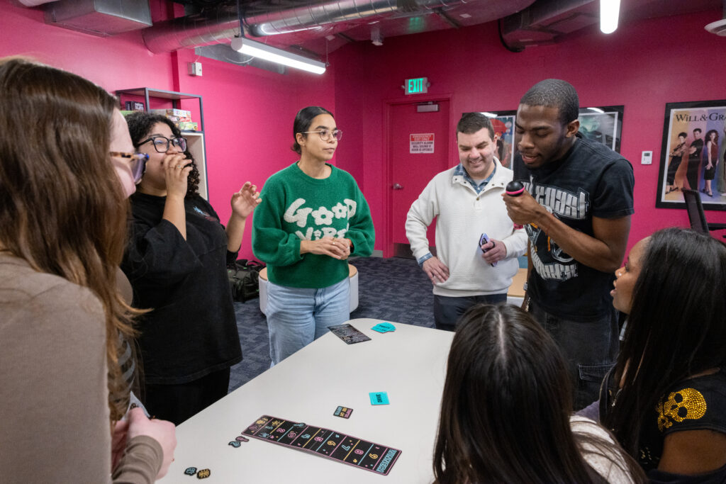 People gather around each other while playing a game
