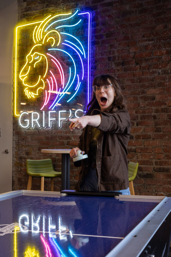 A person points energetically while playing air hockey