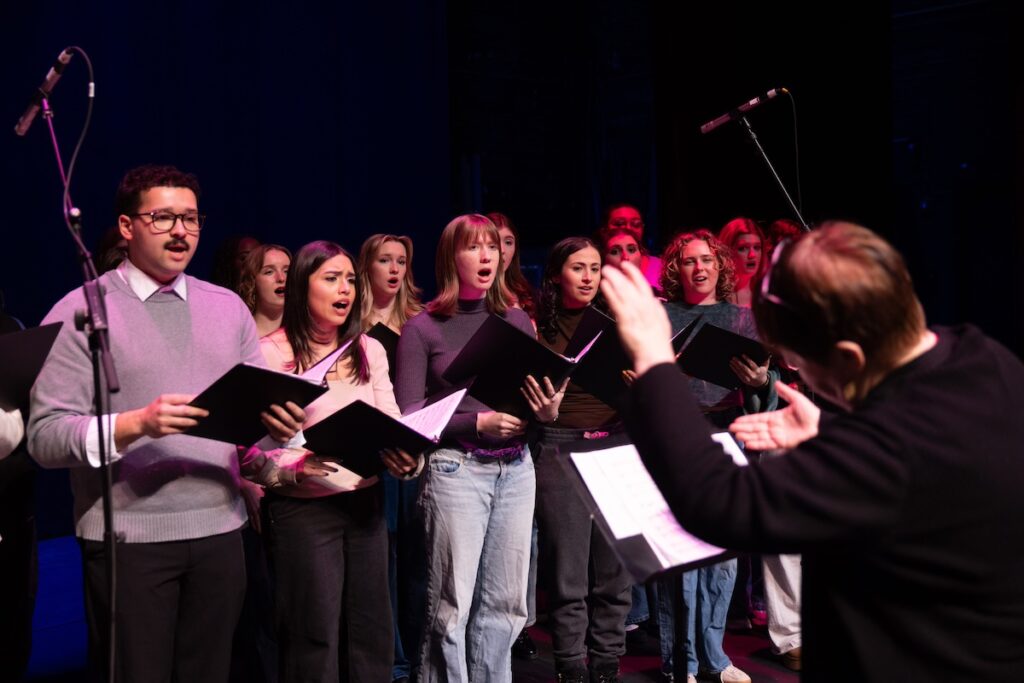 Photo of musical theatre students and associate professor Sariva Goetz rehearsing before their performance with actress Sutton Foster