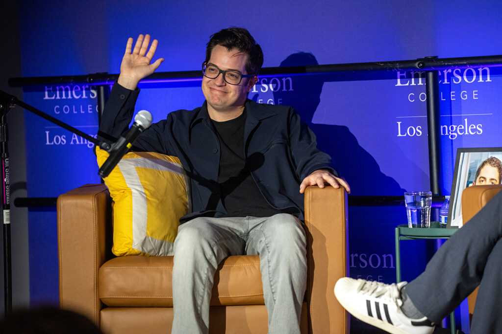 Dan Perrault sits in leather chair, waves