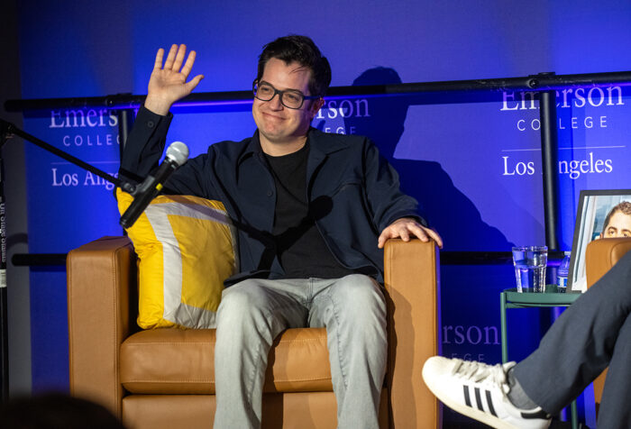 Dan Perrault sits in leather chair, waves