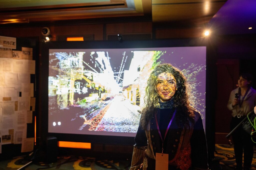 Asma Khoshmehr stands in front of a screen of her installation