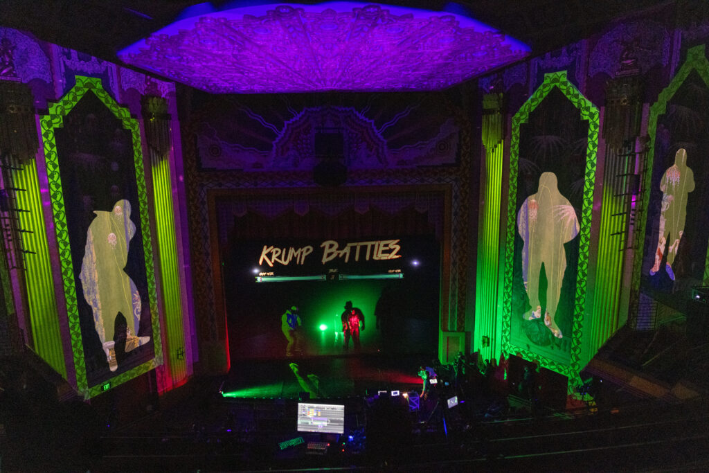 A far back look at the stage with people in a krump battle