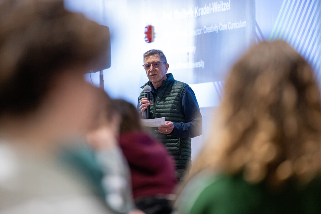 Man holding paper speaks into microphone