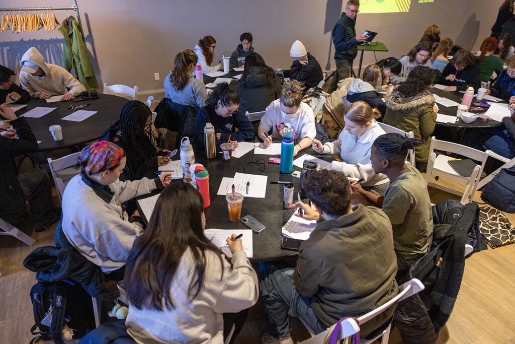 students sit around round tables