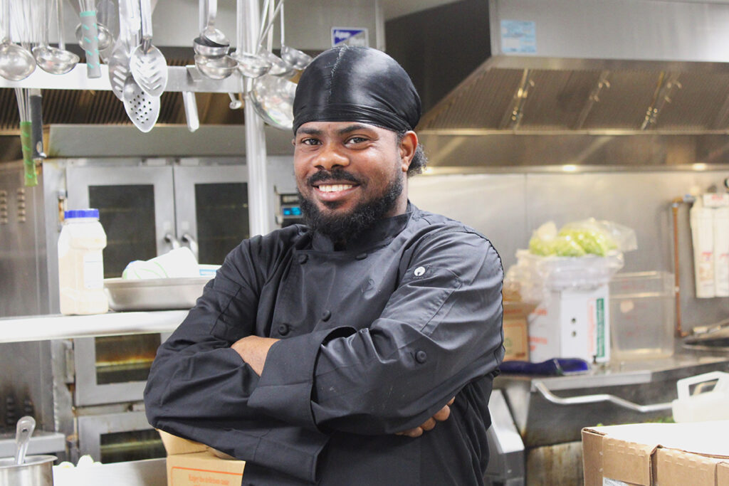 Johnley Victorin stands in kitchen, arms crossed