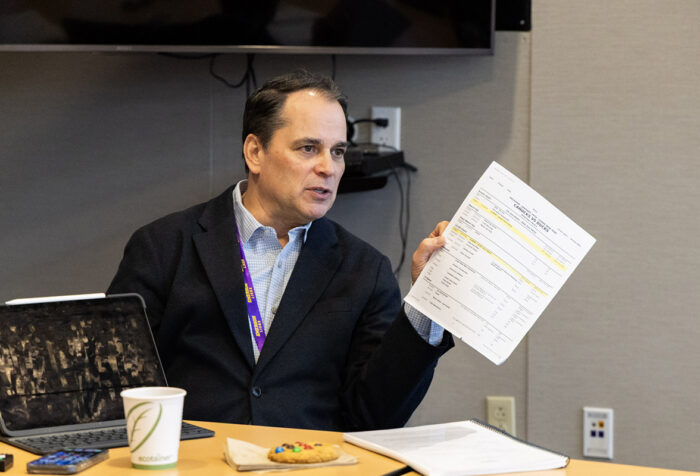 Tim Neverett holds a piece of paper while talking