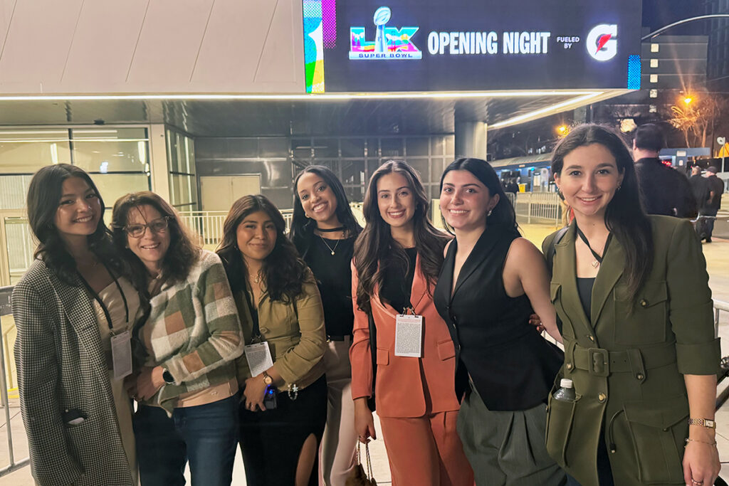 six women stand in front of building with marquee reading LX Opening Night