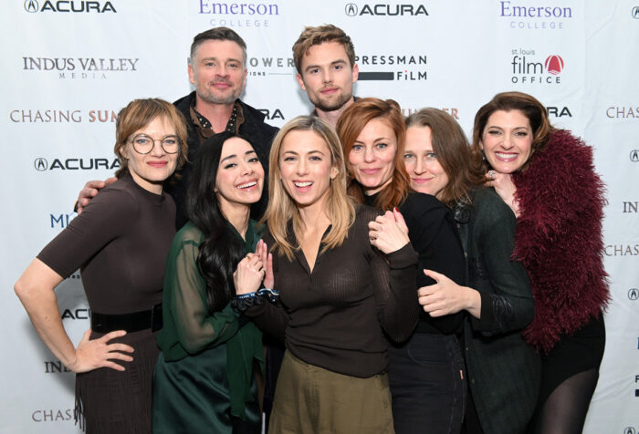 Iliza Shlesinger with numerous people in front of backdrop