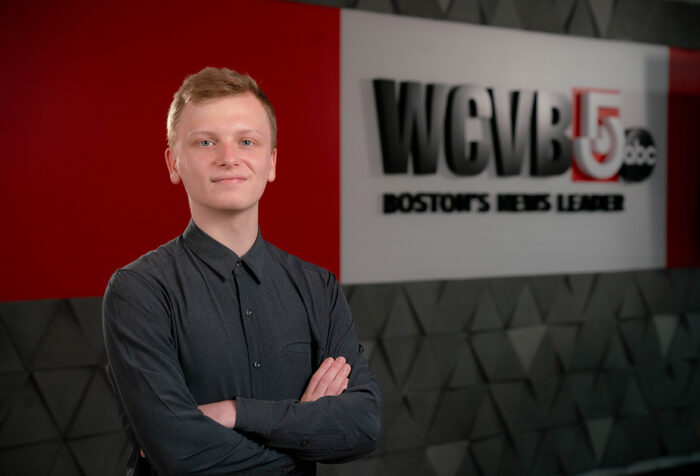 Aidan Vahey standing in front of a WCVB wall