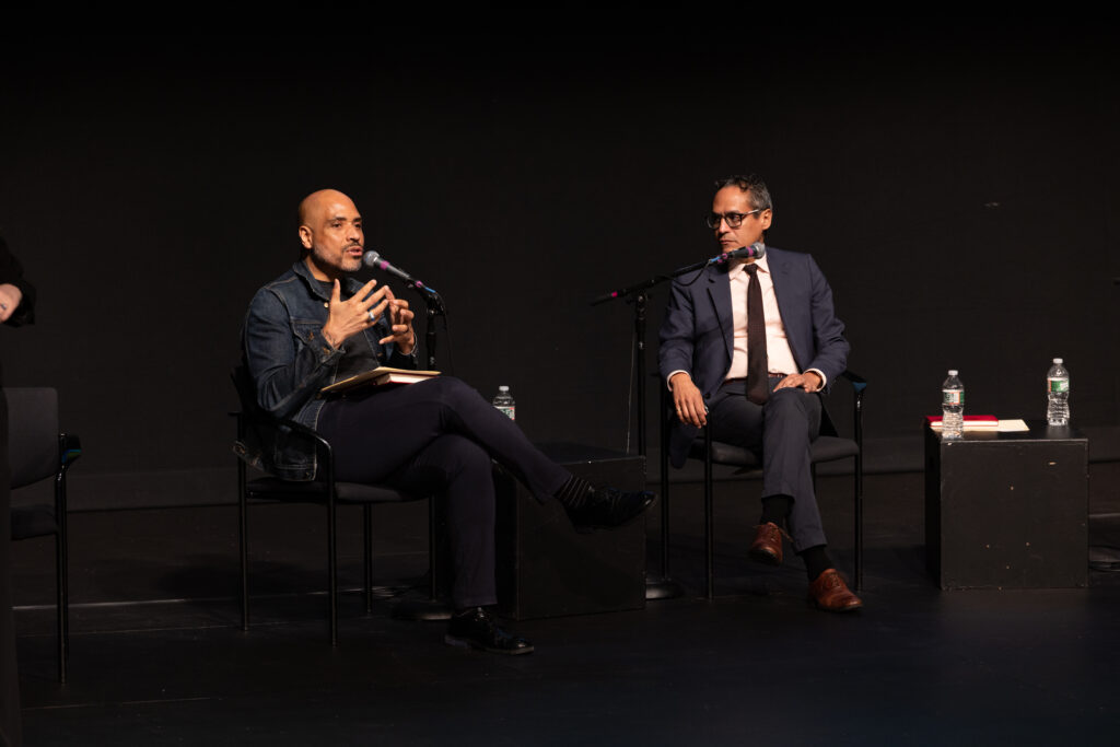 Michael Bobbitt and Roosevelt Montás sit in chairs while participating in the panel 