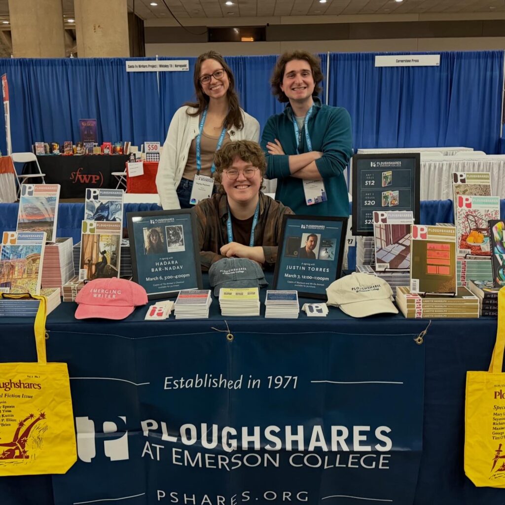 Three staff members of Ploughshares are behind the magazine's table while posing for a photo