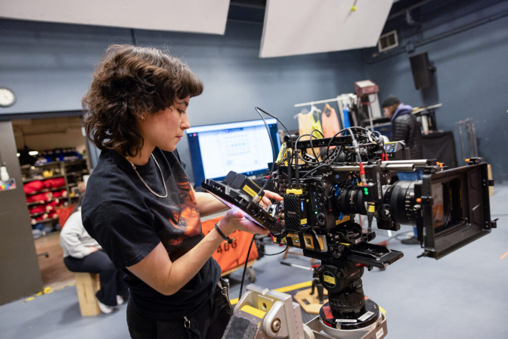 A student looks at a TV camera