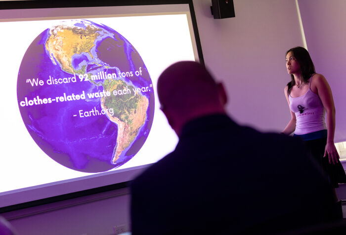 Student presents in front of screen showing a photo of Earth