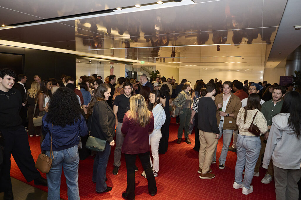 Crowd in a room with red carpet