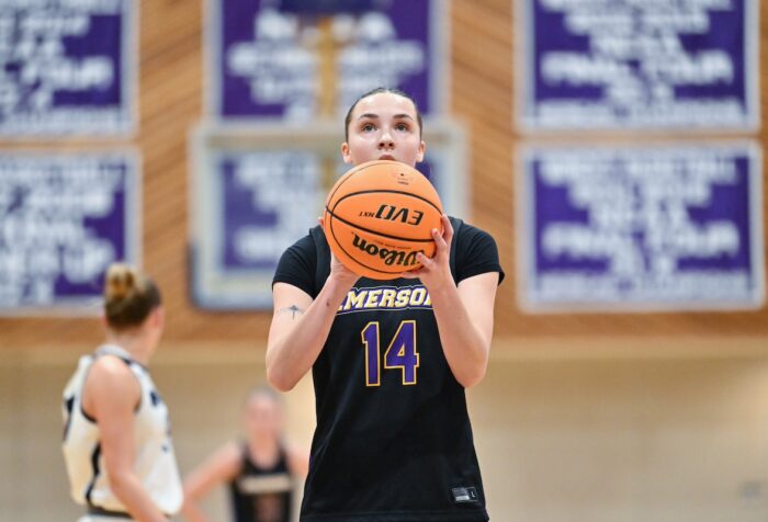 Kaylin O'Meara stands holding a basketball, ready to take a shot during a game