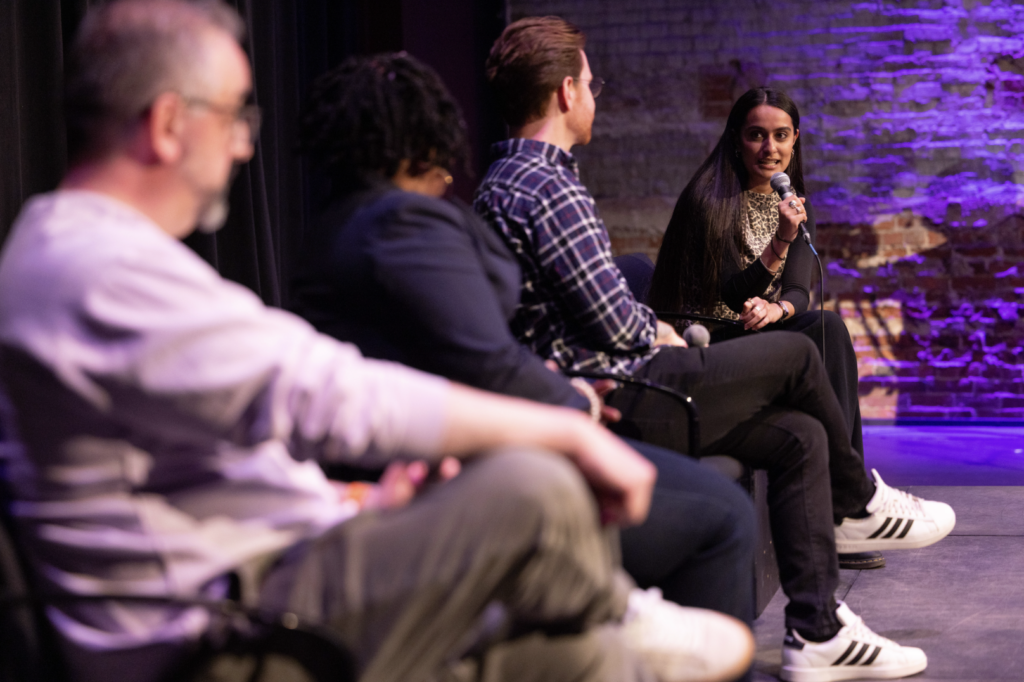 Diti Kohli moderates a panel discussion while everyone sits in chairs