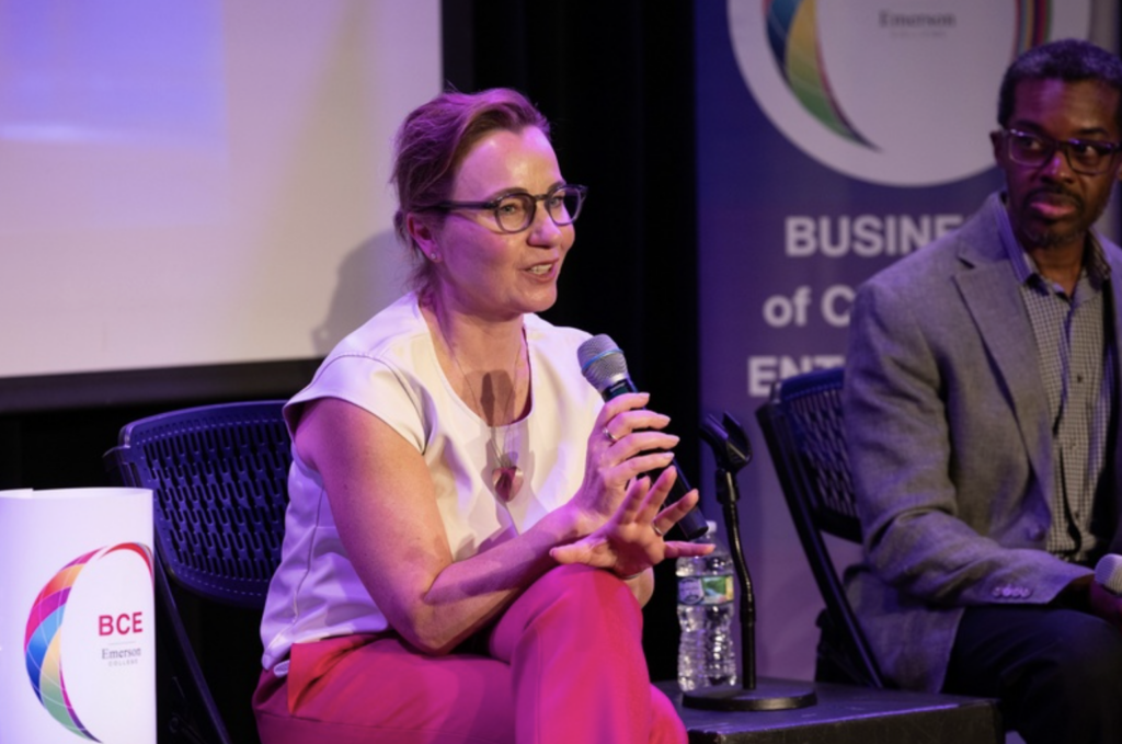 Nina Webb speaks while sitting and holding a microphone
