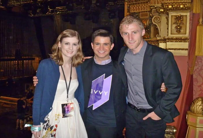 Three people stand together posing for a photo