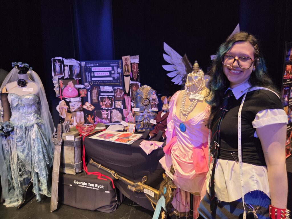 Georgianne Ten Eyck at her table with dresses and other things she's made