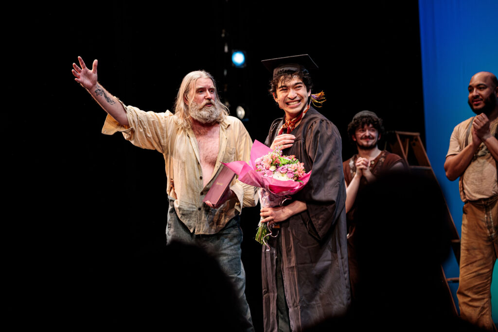 Nicholas Papayoanou receives flowers during his own own private commencement ceremony during the curtain call for Swept Away.