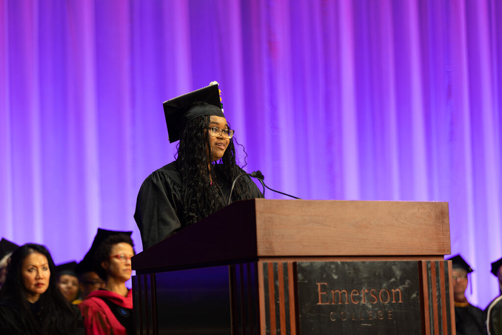 Aniaha Ortiz speaks at podium in cap and gown