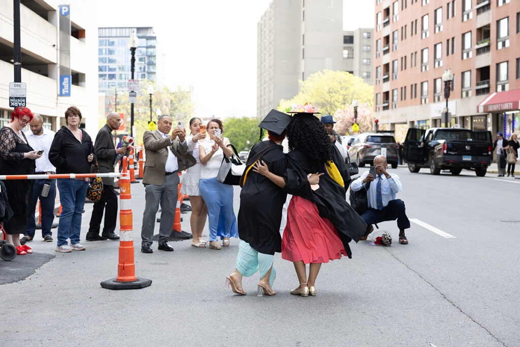 Graduates pose for a cell phone photo on the street