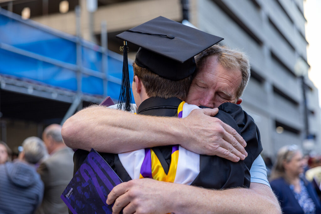 Man hugs graduate