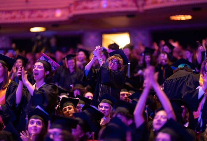 Undergraduate students cheering from their seats