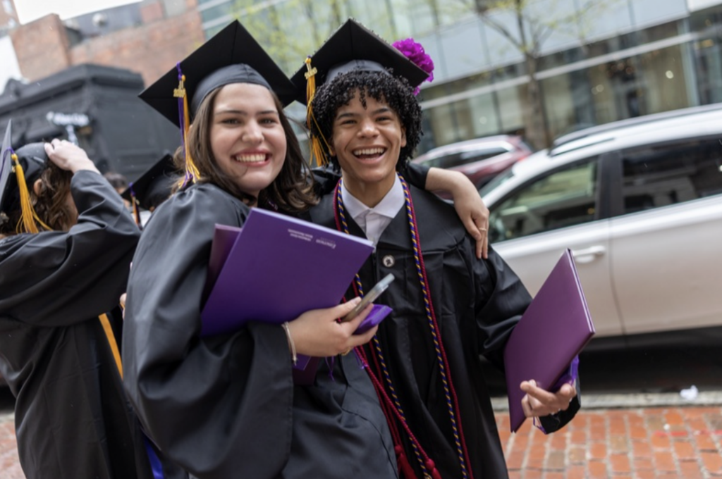 Two graduates pose for a photo