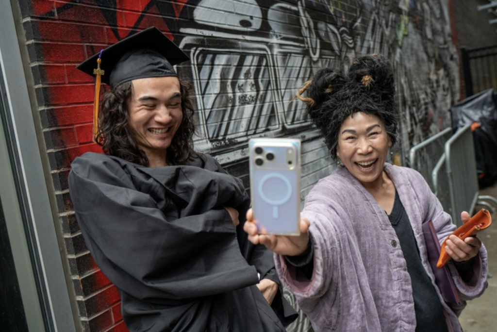 A parent takes a selfie with their graduate