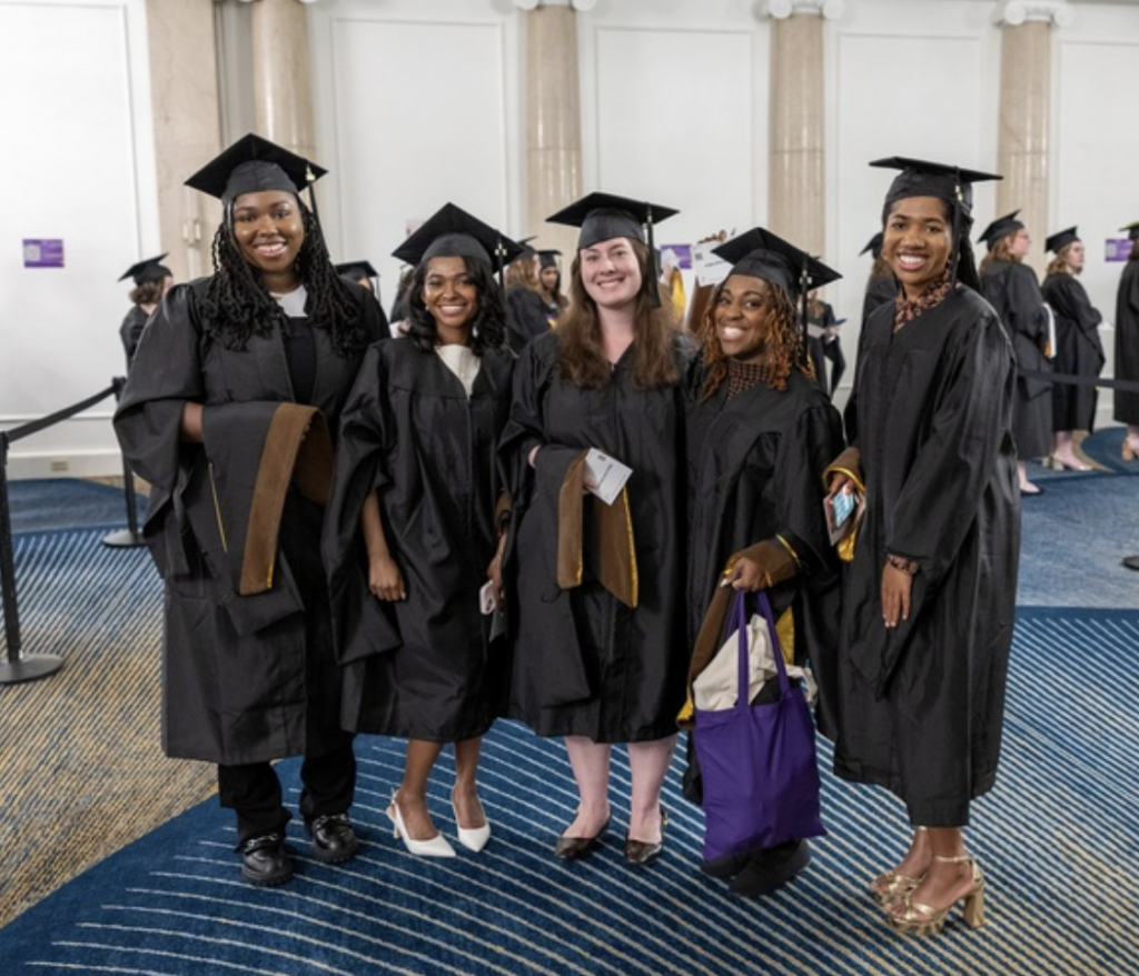 Five graduates pose for a photo